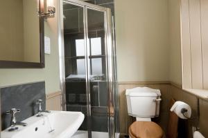 a bathroom with a shower and a toilet and a sink at Balnakeil Beach Bothy in Durness