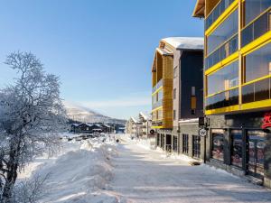 a street covered in snow next to a building at Holiday Home Levin kunkku b8 by Interhome in Levi