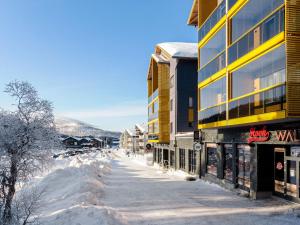 a snow covered street in a town with buildings at Holiday Home Levin kunkku b8 by Interhome in Sirkka