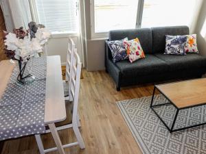 a living room with a couch and a table at Holiday Home Levin kunkku b8 by Interhome in Levi +17 photos
