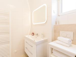 een witte badkamer met een wastafel en een spiegel bij Vienna Apartment 1010 in Wenen