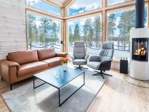 a living room with a couch and two chairs and a fireplace at Holiday Home Villa gaissa by Interhome in Raattama