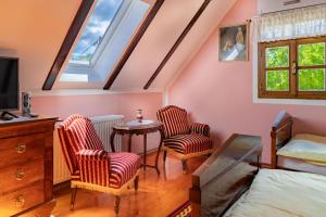 a bedroom with two chairs and a table and a bed at Moslavačka Priča Holiday Homes in Mala Ludina
