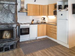 a kitchen with white appliances and a fireplace at Holiday Home Venuskukkula by Interhome in Äkäslompolo