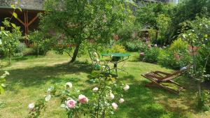 a garden with a table and chairs and flowers at Les Hirondelles in Sainte-Suzanne