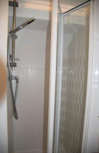 een douche met een glazen deur in de badkamer bij Secret Retreat in Bowness-on-Windermere