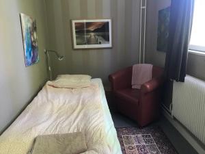 een kleine kamer met een bed en een stoel bij Rytterne Kyrkskola in Sorby