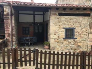 a wooden fence in front of a house with a table at CASA TINA in Ruiseñada