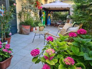 un patio con flores, mesa y sillas en La terrazza San Salvario, en Turín