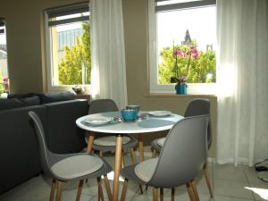 una mesa y sillas en una sala de estar con ventanas en appartement marléne en Potsdam