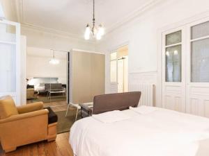 a bedroom with a bed and a chair and a living room at Amazing down town, near guggenheim. céntrico in Bilbao