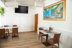 a dining room with a table and a painting on the wall at Garni Moderno in Bellinzona