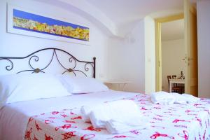 una camera da letto con un letto bianco e asciugamani di Il Borghetto Apartments & Rooms a Procida