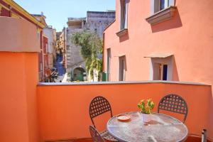 une table et des chaises sur le balcon d'un bâtiment dans l'établissement Il Borghetto Apartments & Rooms, à Procida