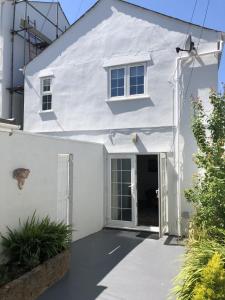 a white house with a door and a window at The Cottage in Redruth