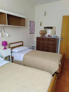 una camera con due letti e un comò con un comò di La Casa di Sandra a Porto Potenza Picena