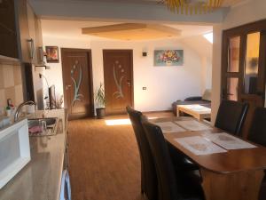 Casa Flori في كاليمانيشتي: مطبخ وغرفة طعام مع طاولة وكراسي