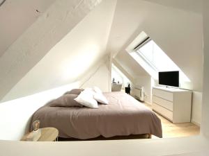 una camera bianca con un letto e una finestra di LA CLE DES TOITS a Colmar