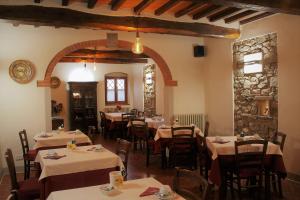 un restaurante con mesas y sillas y una pared de piedra en Agriturismo Poggio de Papi, en Cantagrillo
