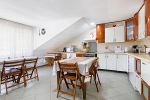 a kitchen with white cabinets and a table and chairs at Casa Dacică in Râşnov +39 photos