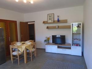 un soggiorno con tavolo da pranzo e TV di Apartment Antica a Baška