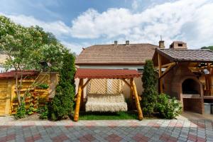 a house with a gazebo in the yard at Casa Dacică in Râşnov