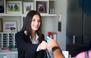 una mujer con una tarjeta de crédito en la mano en Hotel Villa Regina, en Međugorje