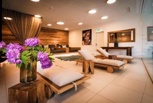 a living room with couches and a vase of purple flowers at Sun Lodge Schladming by Schladming-Appartements in Schladming