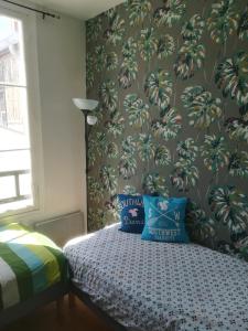 a bedroom with a bed with blue pillows at Bakia in Biarritz