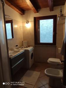 a bathroom with a sink toilet and a window at Secret Garden Mandello in Mandello del Lario +3 photos
