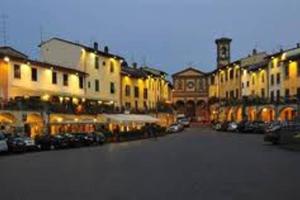 ulica miejska z budynkami i samochodami oraz wieżą zegarową w obiekcie Happy Florence Matteotti Square Greve w Greve in Chianti