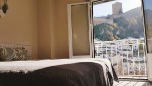 Schlafzimmer mit einem Bett und einem großen Glasfenster in der Unterkunft La Casa De Mariana in Cazorla