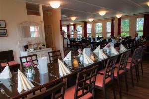 a long table in a room with tables and chairs at Ferienstätte und Seminarhaus Theodor-Schwartz Travemünde in Lübeck