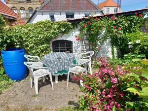 une table et des chaises dans un jardin fleuri dans l'établissement Høkeriet C, à Nordborg