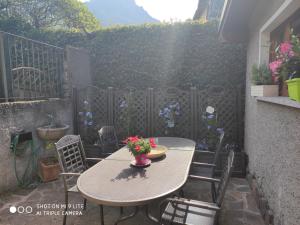 a patio with a table and chairs with flowers on it at Secret Garden Mandello in Mandello del Lario