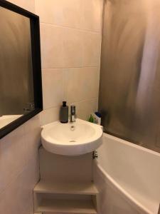 ein Badezimmer mit einem weißen Waschbecken und einer Badewanne in der Unterkunft Splendid 1 Bedroom Flat + Terrace (Kentish Town) in London