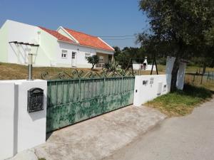 uma cerca em frente a uma casa branca em Villa Gonçalo nas Caldas da Rainha