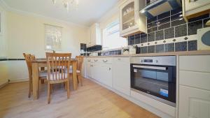 a kitchen with a table and a stove top oven at The Old Tramhouse Self Catering Apartments in Stirling