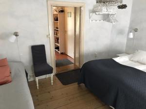 1 dormitorio con 1 cama y 1 silla en Brunius Bed and Breakfast, en Lund