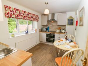 een kleine keuken met een tafel en een wastafel bij School House Cottage in York