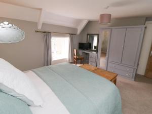 a bedroom with a bed and a desk with a television at School House Cottage in York