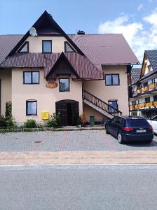 a house with a car parked in front of it at Podhalanka Pokoje in Zakopane