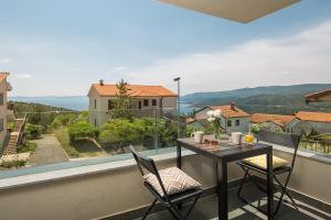 a balcony with a table and chairs and a view at Lemechi Casa Girasole Apartments in Rabac