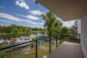 a balcony with a view of a river at Marina Apartments in Wrocław