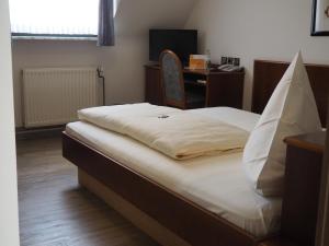 a bedroom with a bed and a desk with a computer at Hotel Bienefeld in Korschenbroich