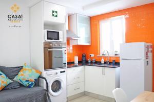 a small kitchen with a washer and dryer and a microwave at Casa do AZULejo - Orange in Peniche