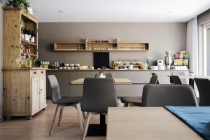 a restaurant with a table and chairs and a counter at Pension Appartment Hecherhof in Merano