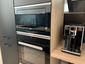 a microwave oven sitting on a shelf with a coffee maker at Relax & Spa - Séjour Romantique in Margny-lès-Compiègne