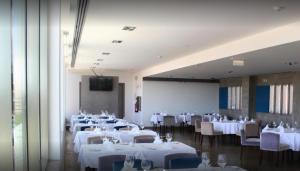 a dining room with white tables and chairs and a tv at Herdade dos Salgados in Albufeira