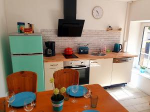 a kitchen with a table with chairs and a refrigerator at Große Bauernhaus Ferienwohnungen bis 100qm mit Grillhütte & Garten & E-Bike-Verleih in Bad Rothenfelde